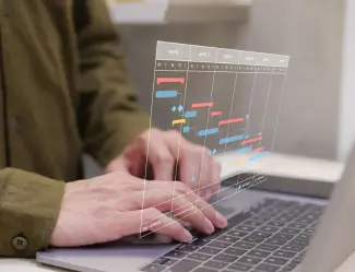 Hands typing on a laptop with a project management chart overlay, illustrating ERP project planning and execution.