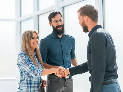 Business professionals shaking hands to finalize an ERP implementation partner decision.